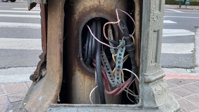 The base of a streetlight that has been vandalized by copper wire theft.